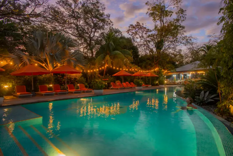 Bodhi Tree Yoga Resort's saltwater pool lit at dusk