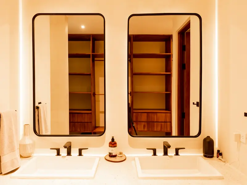 Ensuite double vanity reflecting the walk-in closet