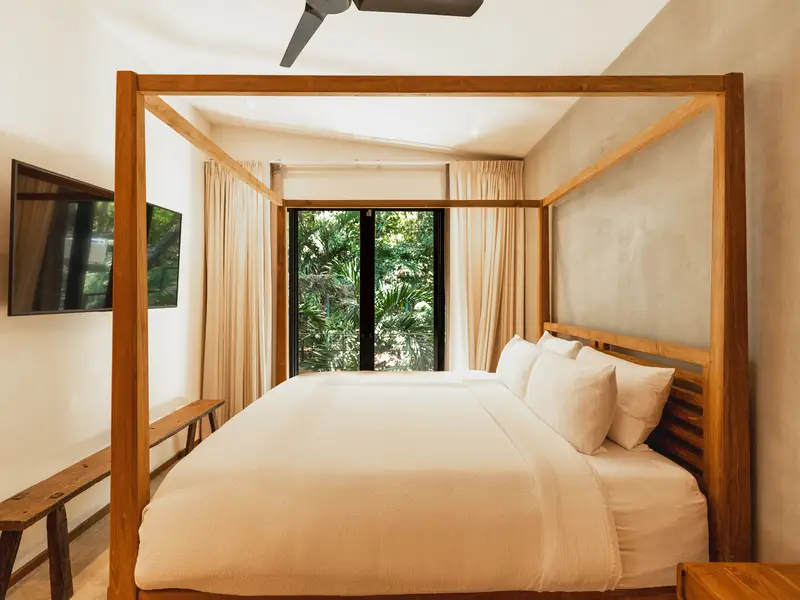Four-poster king bedroom with wall-mounted TV