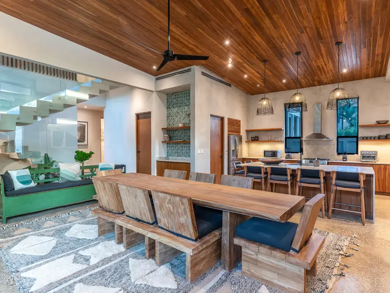 Double-height great room at Kirana Nosara with dining table and floating staircase