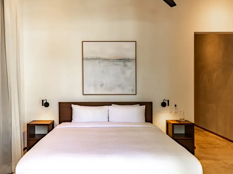 Minimal king bedroom with linen bedding and wall sconces
