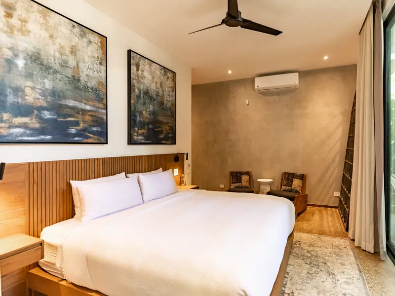 King bedroom with textured plaster walls and reading chairs