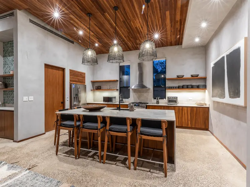 Kitchen at night with pendants lit over the island