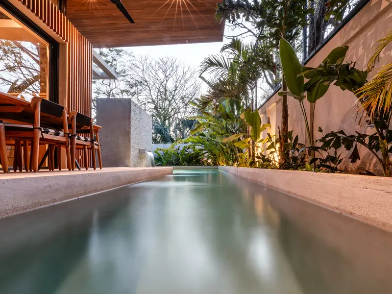 Long lap-style pool seen from water level at dusk