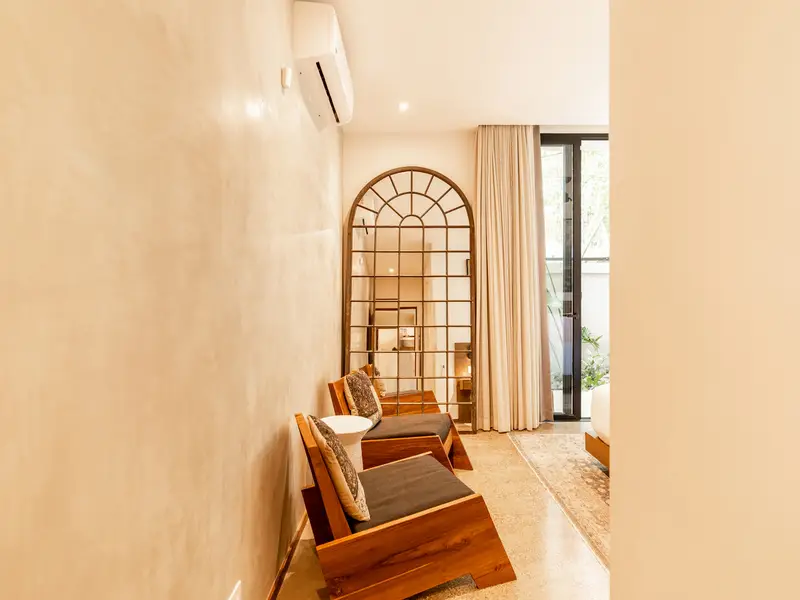 Quiet reading nook with arched mirror and hardwood chairs